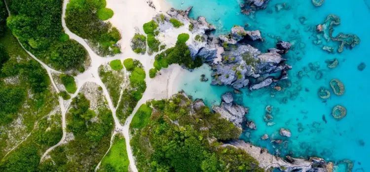 Aerial view of pristine Bermuda coastline with turquoise waters, coral reefs, and lush tropical vegetation