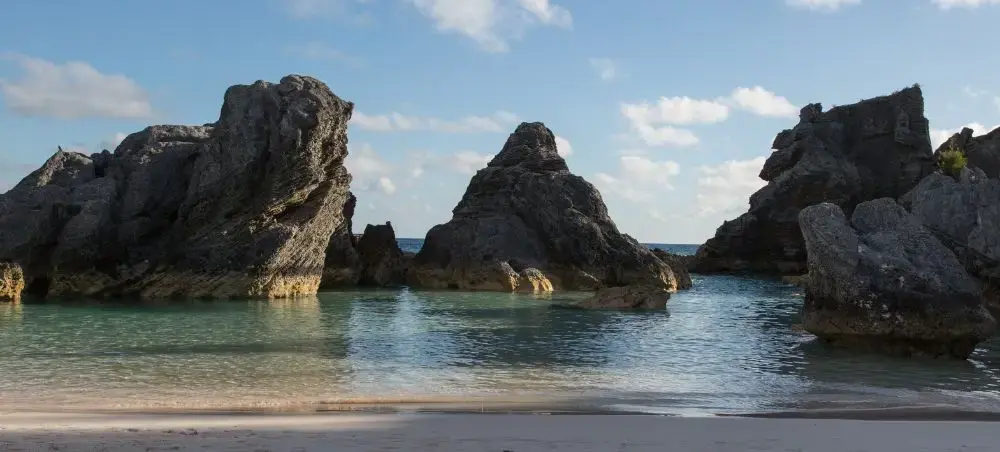 Dramatic limestone rock formations rising from turquoise waters at a pristine Bermuda beach destination