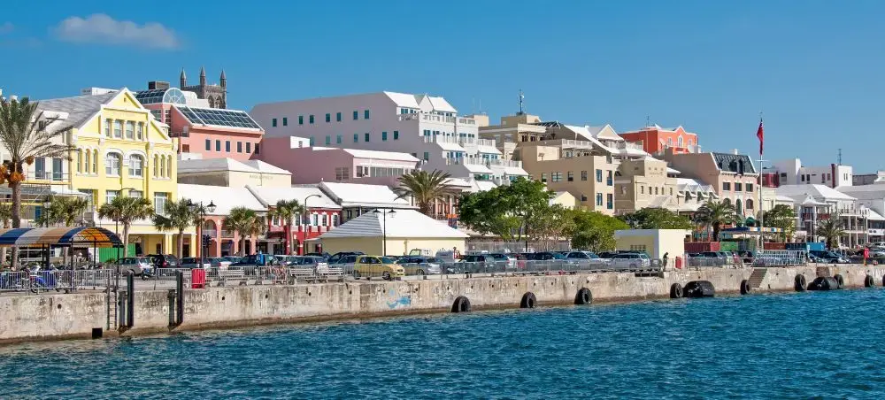 Colorful colonial buildings line Hamilton Harbor waterfront in Bermuda under bright blue skies