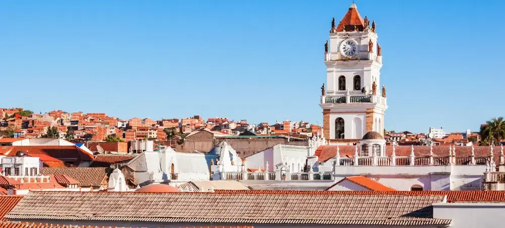 Historic colonial clock tower rises above red-tiled rooftops in Sucre, Bolivia's constitutional capital