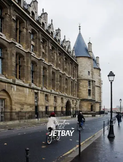 Historic Bordeaux courthouse with Gothic architecture and conical tower on wet cobblestone street
