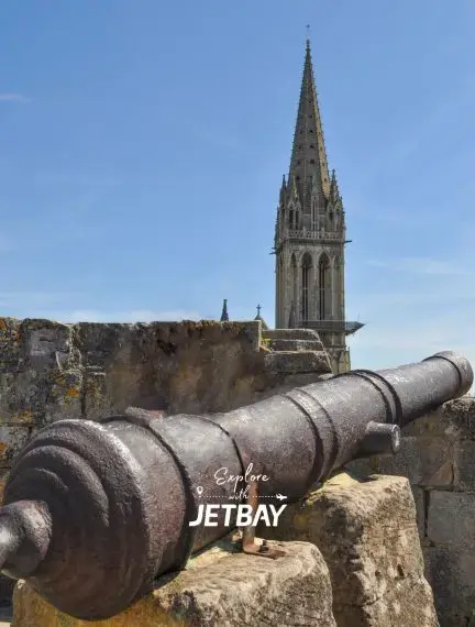 Historic cannon overlooking Bordeaux cathedral spire showcasing medieval architecture and defensive heritage