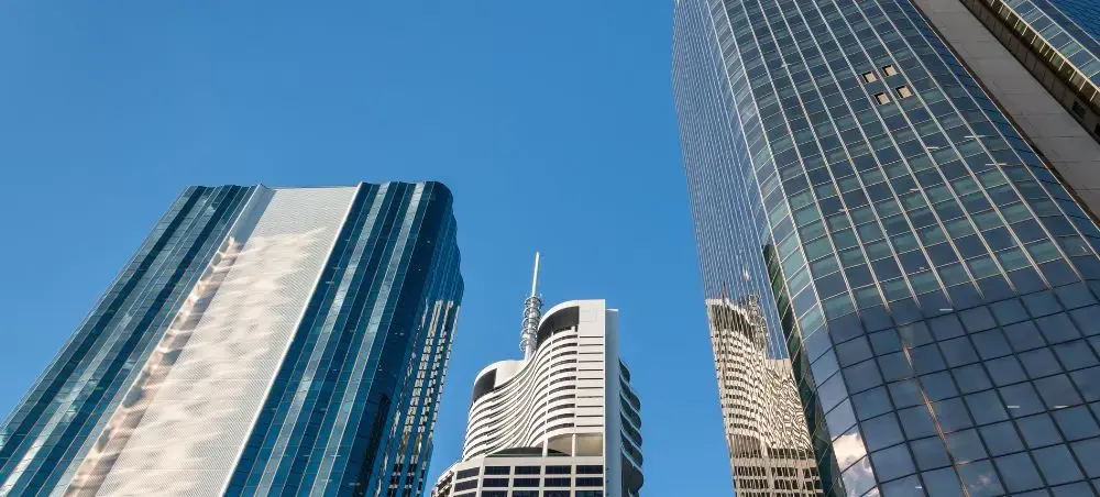 Modern glass skyscrapers reaching toward clear blue sky in Brisbane's central business district