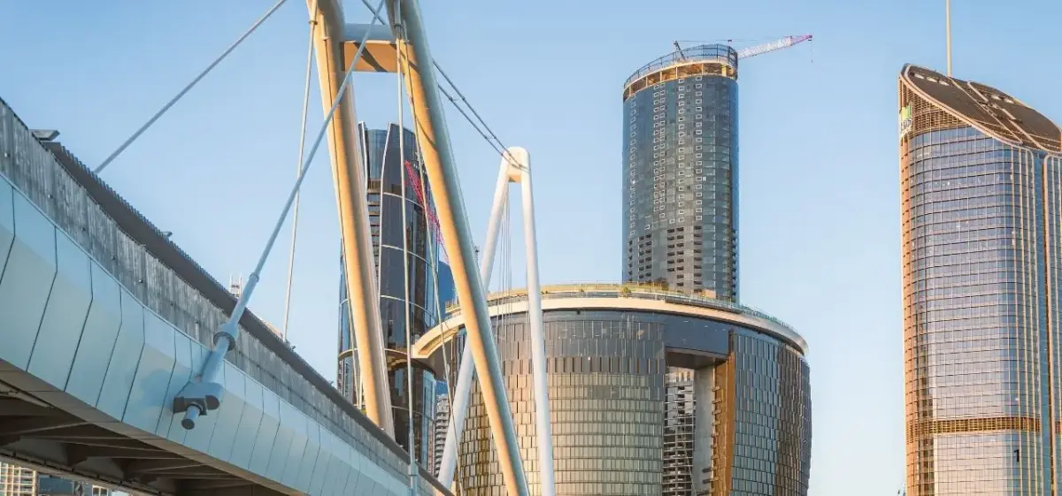 Modern Brisbane skyline featuring glass skyscrapers and pedestrian bridge showcasing Australia's vibrant business district