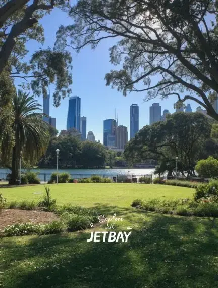 Brisbane city skyline viewed through lush parkland trees with manicured gardens and palm trees in foreground