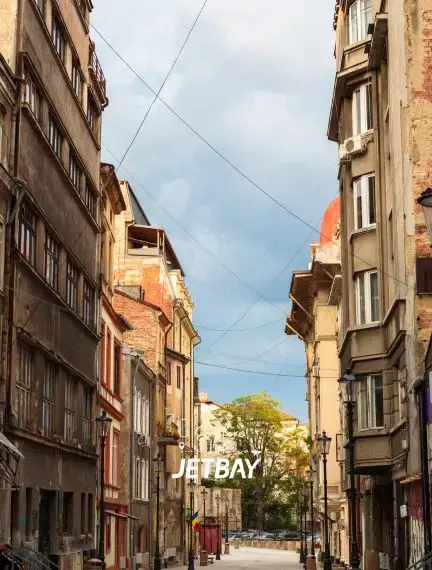 Historic Bucharest street lined with colorful traditional buildings and overhead tram wires