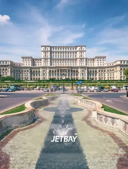 Palace of Parliament in Bucharest with ornate fountain and manicured gardens under blue sky