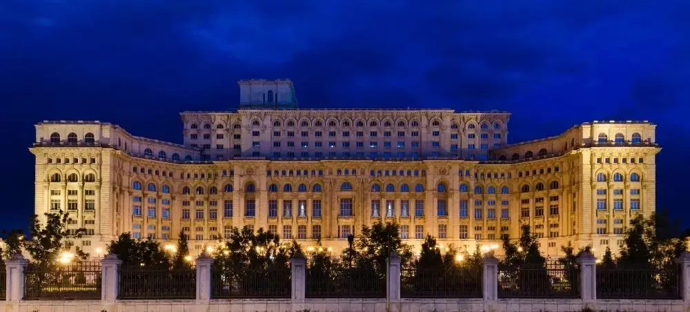 Palace of Parliament illuminated at night in Bucharest, showcasing Romania's grand architecture