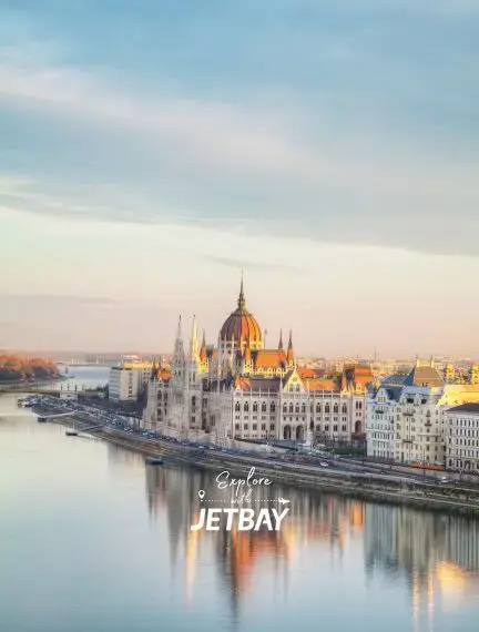 Hungarian Parliament Building illuminated at sunset along the Danube River in Budapest with Jetbay branding