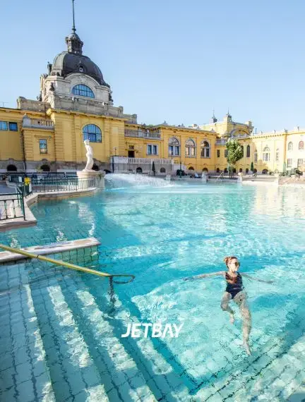 Historic Széchenyi Thermal Baths in Budapest with ornate yellow architecture and relaxing thermal pools
