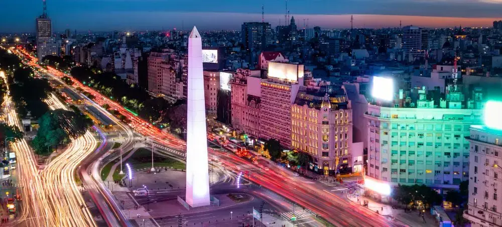 Buenos Aires Obelisk illuminated at twilight with vibrant traffic light trails flowing through the city