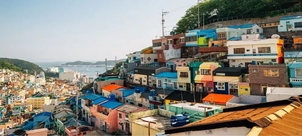 Colorful hillside houses cascade down slopes in Busan's famous Gamcheon Culture Village overlooking the harbor