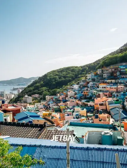 Colorful hillside houses of Gamcheon Culture Village in Busan with Jetbay branding overlooking the harbor