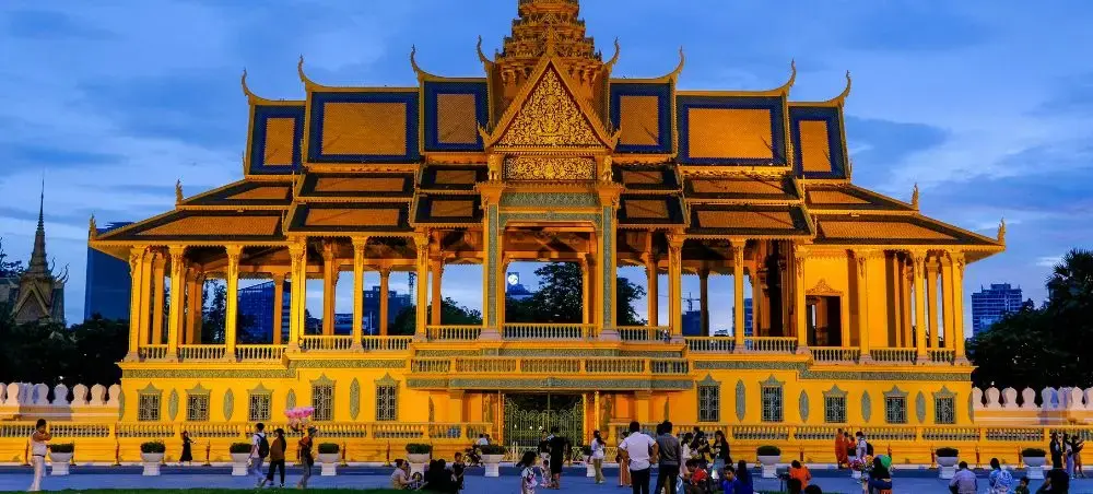 Golden Royal Palace illuminated at dusk in Phnom Penh, showcasing Cambodia's ornate Khmer architecture