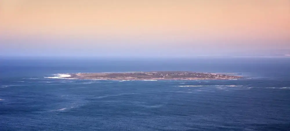 Aerial view of Robben Island surrounded by Atlantic Ocean waters near Cape Town at golden hour