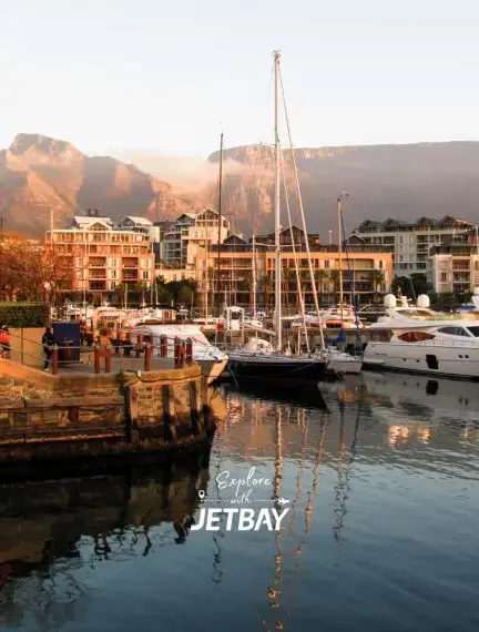Cape Town's V&A Waterfront marina at golden hour with luxury yachts, Table Mountain backdrop, and waterfront hotels