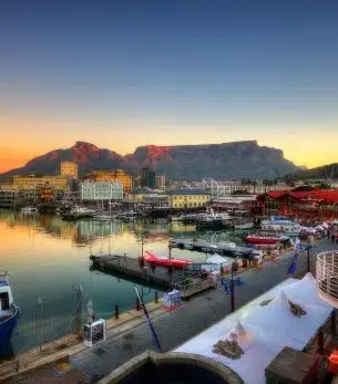 Cape Town's V&A Waterfront marina at sunset with Table Mountain backdrop showcasing luxury travel destination