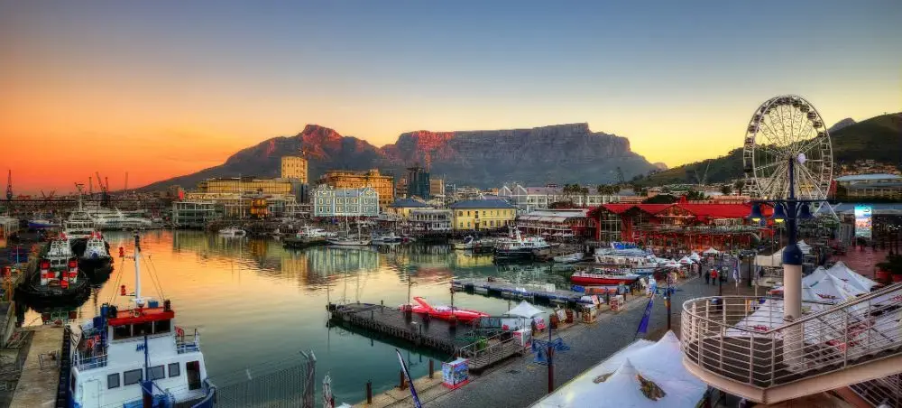 Cape Town's V&amp;A Waterfront at sunset with Table Mountain backdrop, showcasing South Africa's premier luxury travel destination