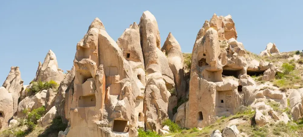 Ancient cave dwellings carved into distinctive fairy chimney rock formations in Cappadocia, Turkey