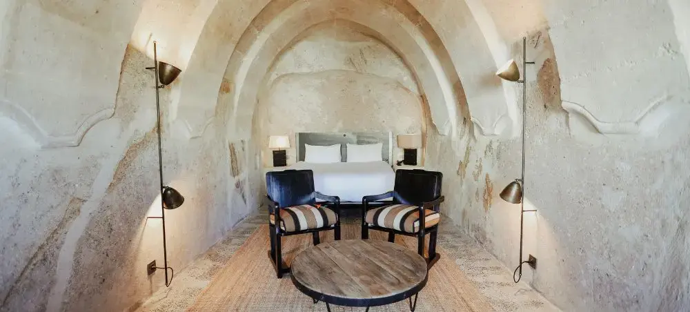 Luxurious cave hotel suite in Cappadocia featuring stone arches, modern furnishings, and traditional Turkish design