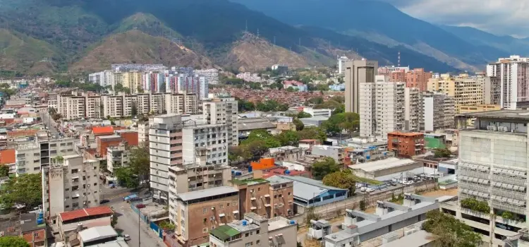 Caracas cityscape with modern high-rise buildings nestled against dramatic Andean mountain backdrop