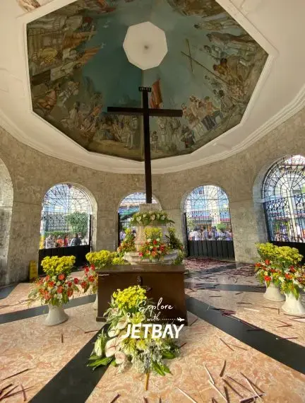 Magellan's Cross shrine interior in Cebu City with ornate ceiling murals and floral arrangements