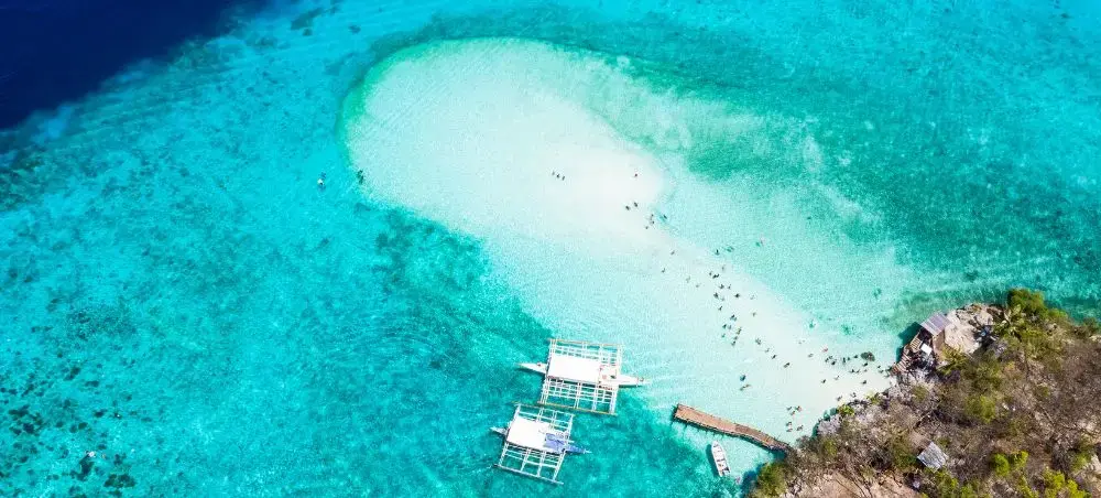 Pristine white sandbar surrounded by turquoise waters near Cebu, showcasing tropical paradise destinations