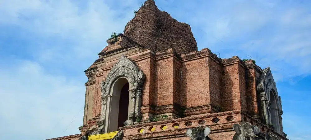 Ancient brick temple ruins with ornate stone carvings showcase Chiang Mai's rich Buddhist heritage