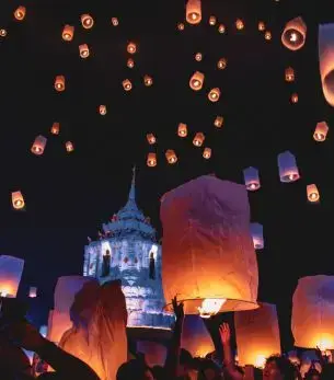 Floating lanterns illuminate Chiang Mai temple during Yi Peng festival celebration in northern Thailand