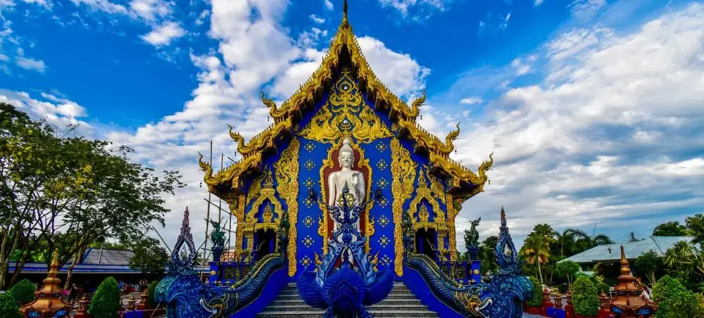 Ornate blue and gold Buddhist temple in Chiang Rai showcasing traditional Thai architecture and artistry