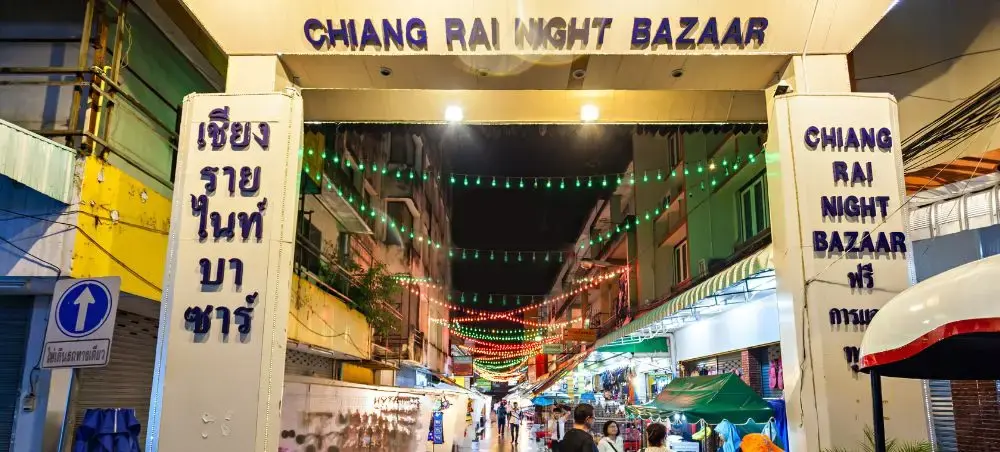 Vibrant entrance to Chiang Rai Night Bazaar with colorful lights and bustling evening market atmosphere