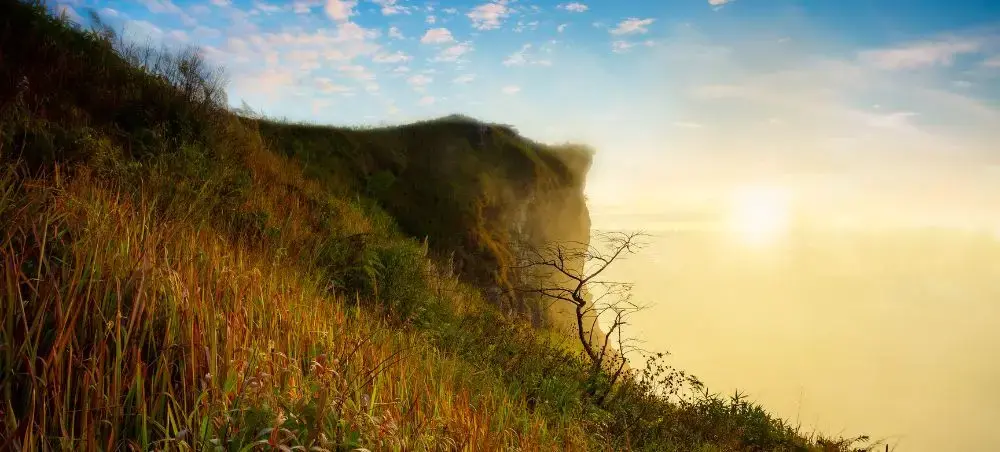 Dramatic sunrise over lush mountain cliffs in Chiang Rai, showcasing Thailand's natural beauty and scenic landscapes