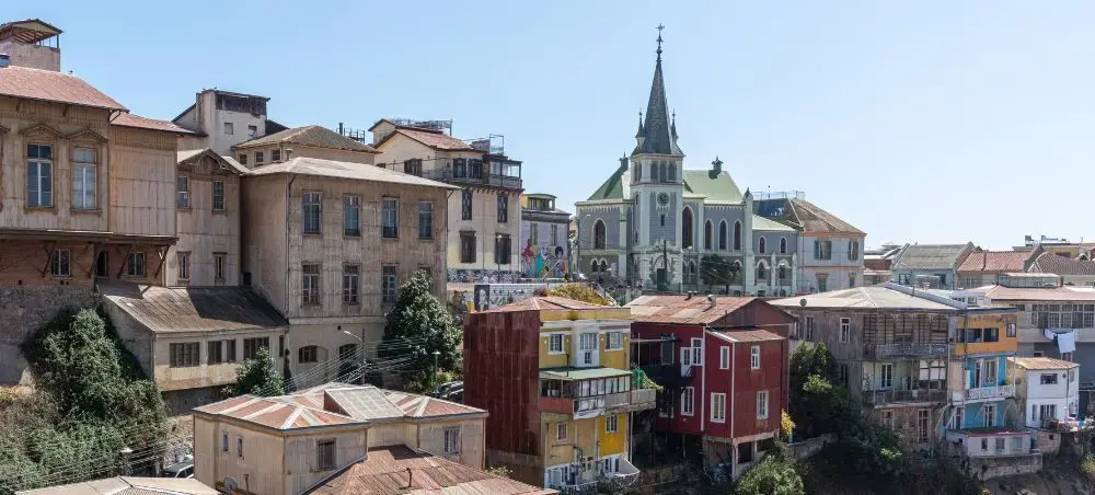 Colorful hillside buildings and historic church tower showcase Valparaiso's distinctive architecture in Chile