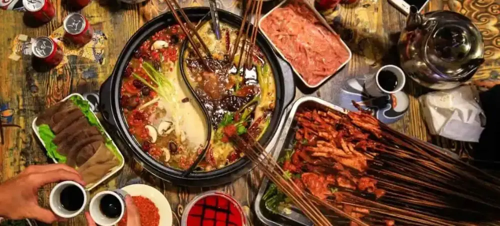 Traditional Chinese hot pot feast with dual-broth base, grilled skewers, and premium ingredients for sharing