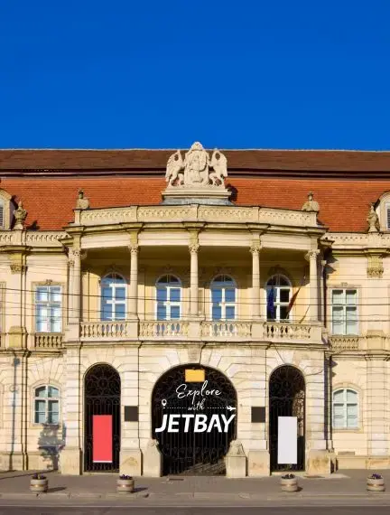 Historic baroque palace with ornate balcony and classical columns in Cluj-Napoca, Romania's cultural center