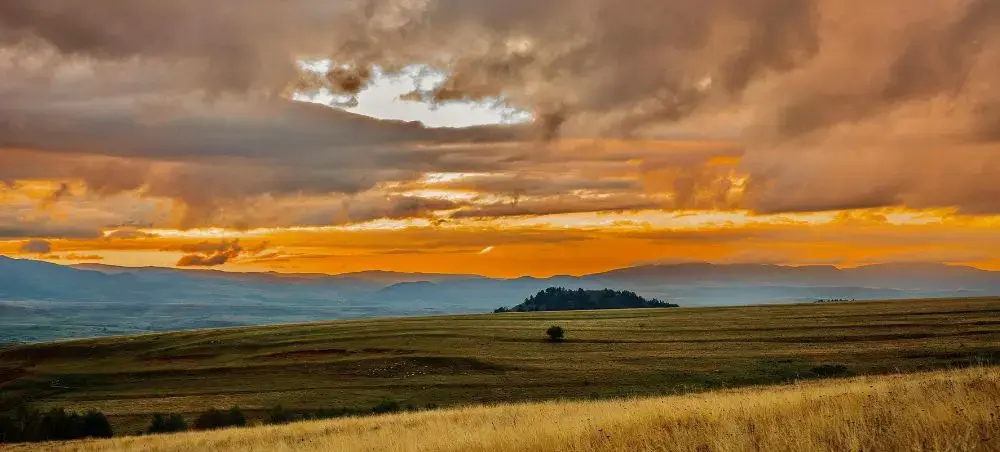 Dramatic sunset over Romanian countryside near Cluj-Napoca with golden clouds above rolling hills