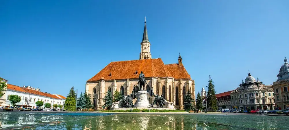 Historic St. Michael's Church and Matthias Corvinus statue in Cluj-Napoca's main square, Romania