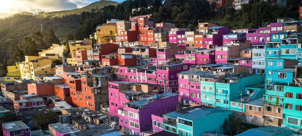 Vibrant colorful houses cascade down hillsides in Colombia, showcasing the country's distinctive architecture