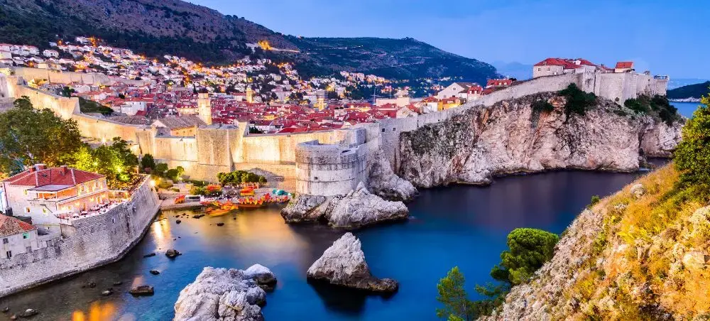 Dubrovnik's illuminated medieval walls and red-roofed old town overlooking the Adriatic Sea at twilight