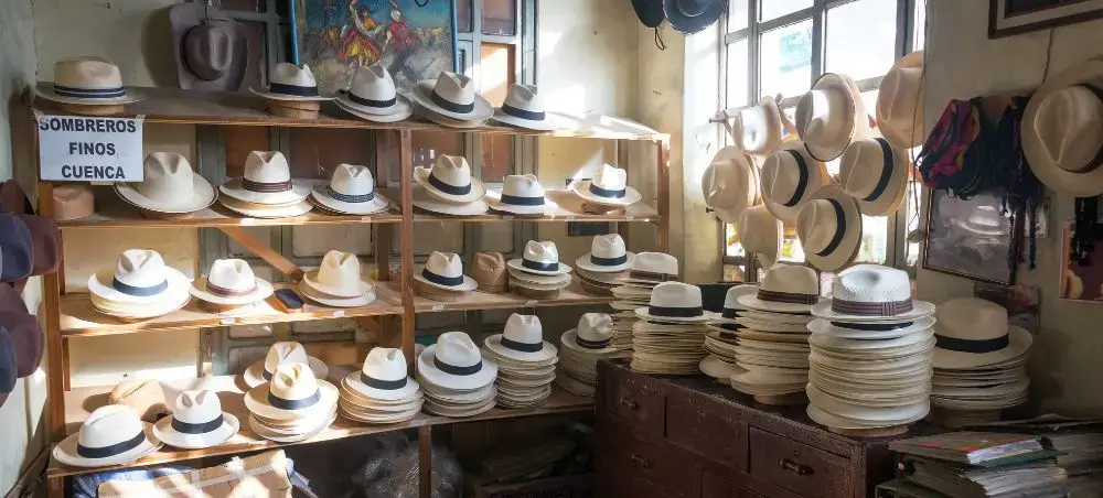 Traditional Panama hat workshop in Cuenca showcasing handcrafted straw hats on wooden shelves and displays