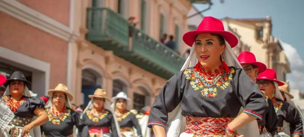 Traditional Ecuadorian dancers in colorful folk costumes performing at cultural festival in Cuenca's historic center