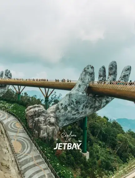 Golden Bridge in Da Nang supported by giant stone hands with tourists walking across mountain landscape