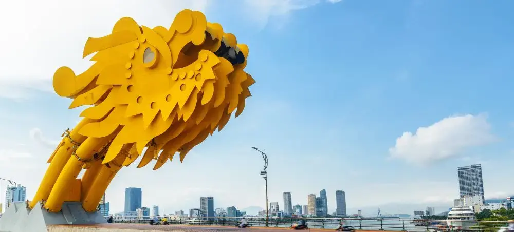 Golden Dragon Bridge spanning Han River with Da Nang city skyline showcasing Vietnam's modern architecture