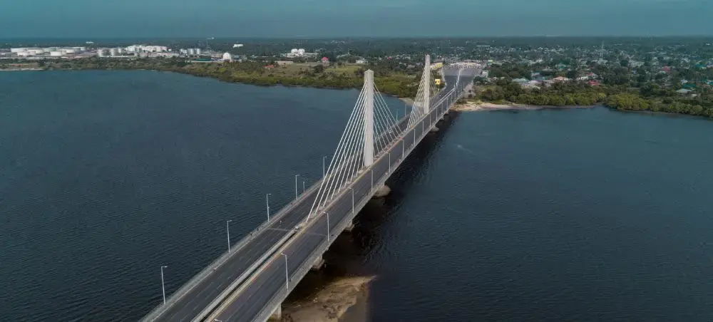 Aerial view of modern cable-stayed bridge spanning blue waters connecting Dar es Salaam districts
