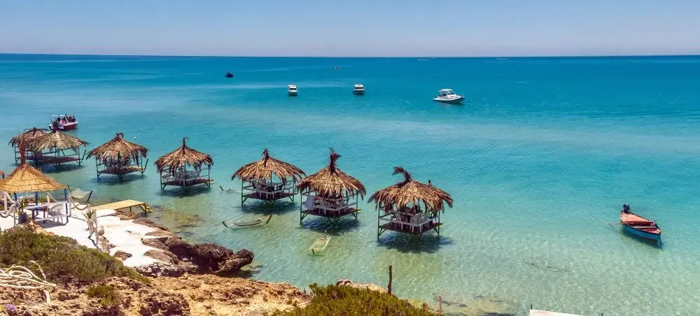 Crystal clear turquoise waters and traditional thatched beach huts in Dar es Salaam's pristine coastline