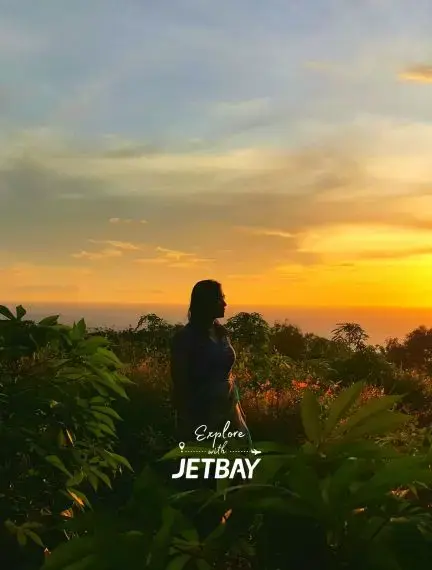 Traveler silhouetted against golden sunset overlooking lush tropical landscape in Davao City, Philippines