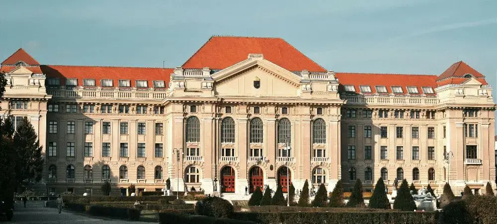 Grand neoclassical university building with red tile roofs and ornate facade in Debrecen, Hungary