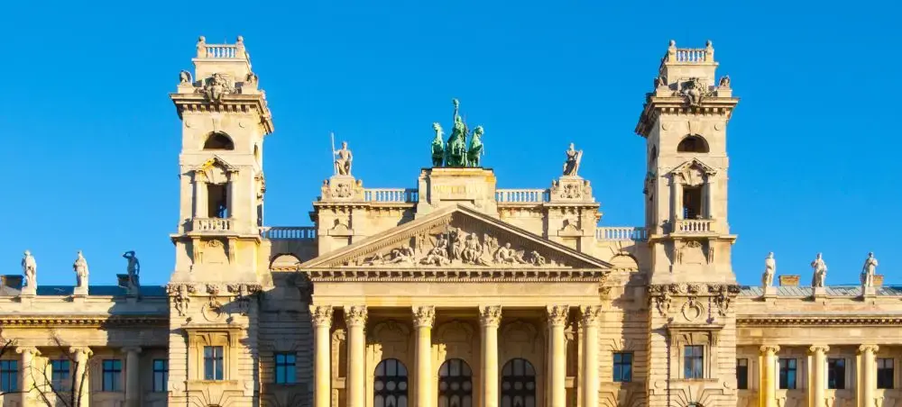 Ornate neoclassical facade of Debrecen Reformed Great Church with twin bell towers under blue sky