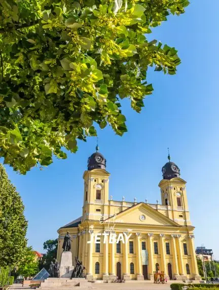 Historic Debrecen Reformed Great Church with twin baroque towers under clear blue sky in Hungary