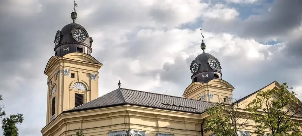 Historic twin-towered Reformed Great Church dominates Debrecen's skyline under dramatic cloudy skies